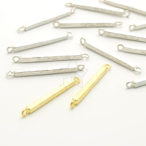 May include: A group of silver and gold bar connectors with two loops on each end. The connectors are textured and have a hammered finish.