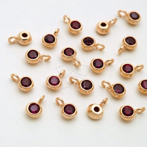 May include: A collection of 20 gold-tone pendant charms with red rhinestone accents. Each charm features a small round red rhinestone with a gold-tone loop at the top.