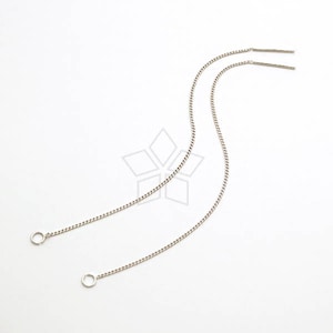 May include: Two silver chain earrings with small circular hoops at the ends. The chains are delicate and have a subtle shimmer.