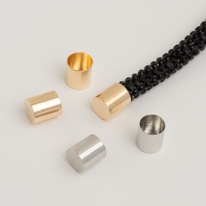 May include: Four metal end caps for cords or jewelry. Two are gold and two are silver.
