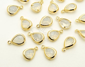 May include: A collection of 18 gold-toned teardrop-shaped pendants with clear faceted glass inserts. The pendants have a loop at the top for attaching to jewelry.
