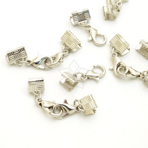 May include: Silver tone metal clasps with a square design and a lobster claw clasp. These clasps are used for jewelry making.
