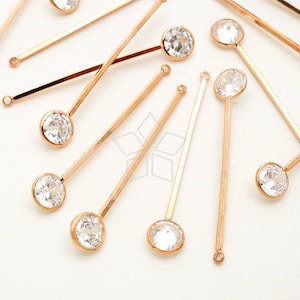 May include: A set of gold-toned hair pins with clear crystal accents. Each pin features a round crystal at the end.