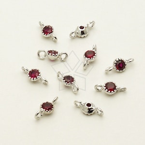 May include: Ten silver-toned jewelry connectors with red gemstone accents. Each connector has two loops for attaching to jewelry pieces.