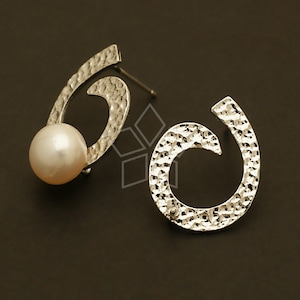 May include: A pair of silver earrings with a hammered texture. Each earring features a circular design with a pearl in the centre.