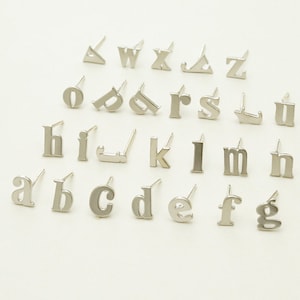 Könnte beinhalten: Silberne Buchstabenohrringe im Alphabet von A bis Z. Die Ohrringe sind klein und zart, perfekt für den Alltag.
