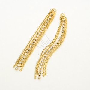 May include: A pair of gold dangle earrings with multiple strands of chain and clear rhinestones.