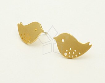 May include: A pair of gold-toned bird-shaped stud earrings. Each earring features a small, detailed bird design with a dotted pattern.