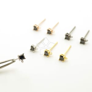 May include: Six pairs of earring findings with black square-shaped stones. The findings are in three different metal finishes: gold, silver, and rose gold.