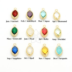May include: Twelve gold-tone charms, each featuring a different colored gemstone, representing the twelve months of the year. The charms are in the shape of a teardrop with a small loop at the top for attaching to a necklace or bracelet. The gemstones are: garnet, amethyst, aqua, diamond, emerald, pearl, ruby, peridot, sapphire, opal, topaz, and turquoise.