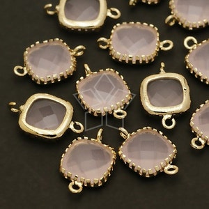 May include: A group of 10 gold-toned metal charms with a square-shaped pink glass stone in the center. Each charm has two loops for attaching to a necklace or bracelet.