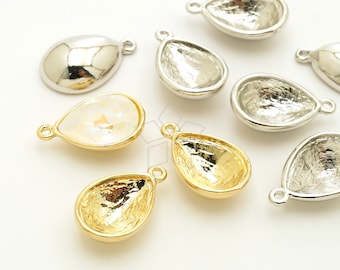 May include: Close-up of several teardrop-shaped jewelry components. Some are silver, some are gold, and one has a clear, faceted stone. Each component has a small loop at the top for attaching to other pieces. The components are likely for jewelry making.