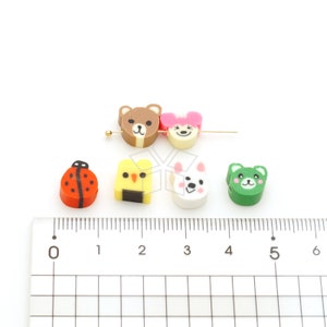 May include: A set of six colorful animal and food themed eraser toppers. The toppers include a brown bear, a pink bunny, a yellow chick, a white rabbit, a green bear, and a red ladybug.