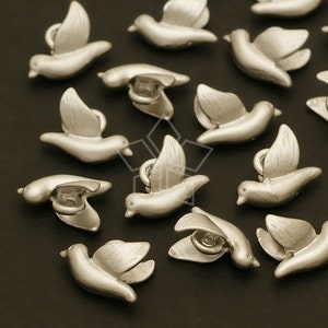 May include: A collection of silver-toned metal dove charms. The doves are in flight and have a detailed design.