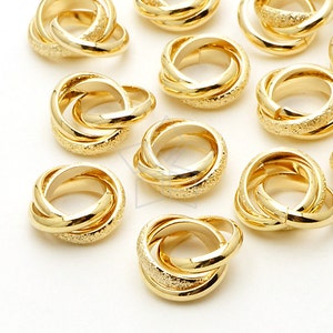 Puede incluir: Un grupo de anillos entrelazados de color dorado. Los anillos son lisos y brillantes, con una superficie texturizada.