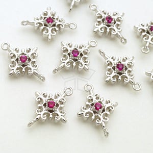 May include: Nine silver-toned metal charms with a filigree design and a pink gemstone in the centre. Each charm has two loops for attaching to jewellery or other crafts.
