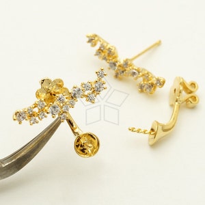May include: A pair of gold-tone ear cuff earrings with a delicate floral design and clear cubic zirconia stones.