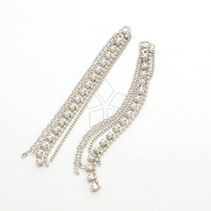 May include: A pair of silver dangle earrings with multiple chains and small beads. The earrings are long and delicate.