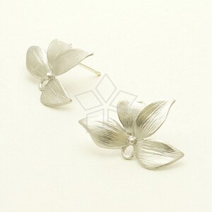 May include: A pair of silver flower-shaped earrings. Each earring features a three-dimensional flower design with a textured finish.