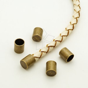 Puede incluir: Cinco tapones de cordón de metal dorado antiguo para cordón o cuerda de cuero. Los tapones de cordón son cilíndricos y tienen una superficie lisa ligeramente texturizada.