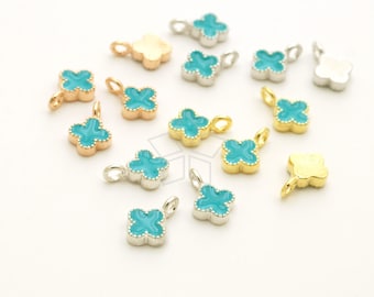 May include: Assortment of small, four-leaf clover charms with turquoise enamel. The charms are made of silver, gold, and rose gold.