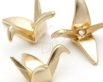 May include: Three gold origami crane charms with a hole for string or wire. The cranes are made of metal and have a shiny finish.