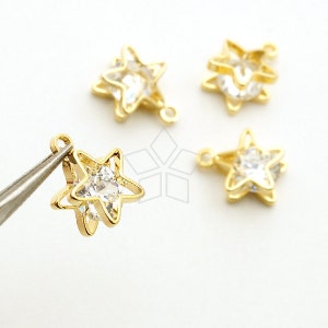Può includere: Quattro ciondoli a forma di stella dorati con accenti di strass trasparenti. Ogni ciondolo ha un anello per il fissaggio a gioielli o altri oggetti artigianali.