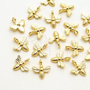 May include: A collection of gold-toned bee charms, perfect for jewelry making or crafting projects. The charms feature intricate details and a realistic bee design.