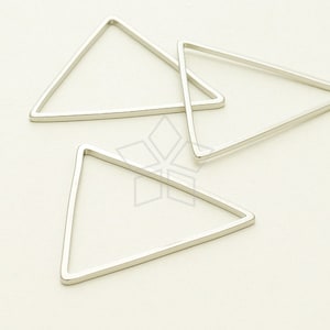 May include: Three silver triangle shapes, each with a different size, are arranged on a white surface.