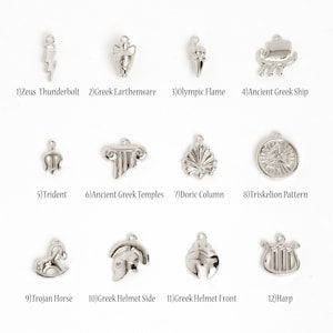 May include: Twelve silver charms featuring a range of Greek mythology and cultural themes. The charms depict a thunderbolt, earthenware, Olympic flame, ancient Greek ship, trident, ancient Greek temples, Doric column, triskelion pattern, Trojan horse, Greek helmet side, Greek helmet front, and a harp.
