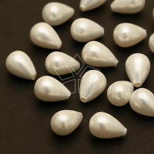 May include: A collection of pearlescent, teardrop-shaped beads. The beads have a smooth, glossy finish and a subtle iridescent sheen. They are scattered across a dark surface, creating a contrast that highlights their shape and color. Ideal for jewelry making.