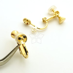 May include: Gold-tone earring clip-on backs with a clear plastic backing. The clip-on backs are designed to be used with earrings that have a post.