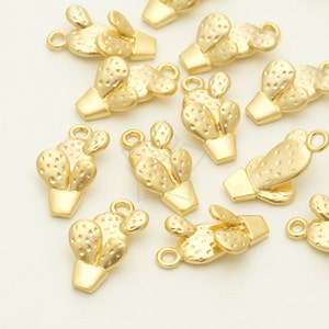 Può includere: Un set di 12 ciondoli a forma di cactus in metallo dorato. Ogni ciondolo presenta un design di cactus dettagliato con un vaso. I ciondoli hanno un anello nella parte superiore per essere attaccati a gioielli o altri oggetti artigianali.