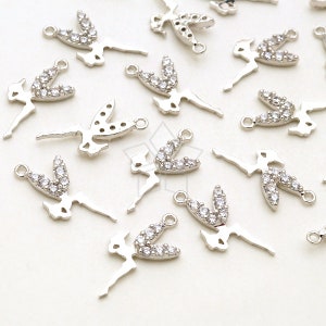 May include: A group of silver-toned metal charms in the shape of a ballerina with clear rhinestones.