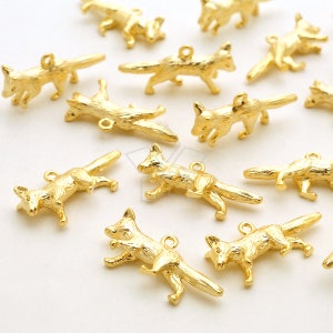 Puede incluir: Una colección de pequeños dijes de zorro dorados. Cada dije está intrincadamente detallado, representando un zorro en varias poses. Los dijes tienen un lazo en la parte superior para una fácil fijación a joyas u otras manualidades. Los zorros son de color dorado brillante.
