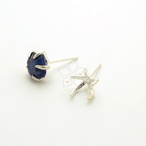 May include: A pair of silver earring settings with a blue lapis lazuli stone in one setting. The settings are shaped like a starfish.
