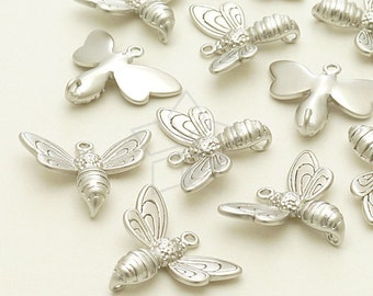 Puede incluir: Una colección de abalorios de abeja plateados con detalles intrincados. Los abalorios tienen forma de abeja con alas y un cuerpo texturizado. Son perfectos para añadir un toque de fantasía a las joyas o las manualidades.