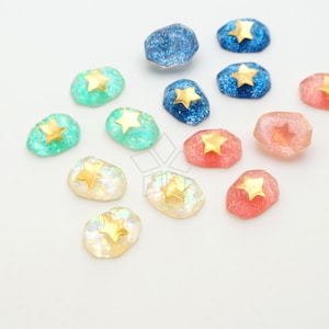 May include: Assortment of colorful resin cabochons with gold star accents. The cabochons are in shades of blue, green, pink, and iridescent white.