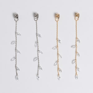 May include: Three pairs of long, dangling earrings with crystal accents. The earrings are available in silver, gold, and rose gold.