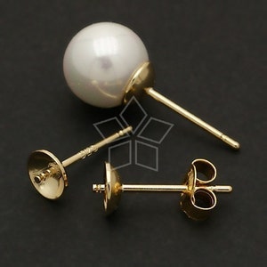 May include: Three gold earring posts with a white pearl on one of the posts. The posts are designed for use with a variety of earrings.