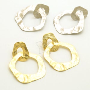 May include: A pair of gold and silver earrings with a hammered, textured finish. The earrings are shaped like two interlocking circles.