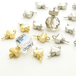 May include: Assortment of gold and silver metal bead caps with a crystal bead and a crystal bottle stopper. The bead caps have a loop on one end and a pin on the other end.