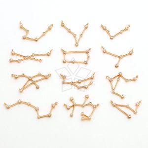 May include: A set of 12 gold-toned zodiac constellation charms with clear crystal accents. Each charm features a different constellation design.