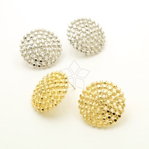 Puede incluir: Un par de pendientes con un diseño redondo y texturado. Un par es dorado y el otro es plateado.