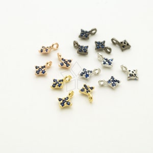 May include: Assortment of small, square-shaped charms with a loop at the top. Each charm is adorned with a cluster of dark blue rhinestones. The charms are available in gold, silver, rose gold, and black.