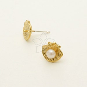 May include: A pair of gold-tone earrings featuring a seashell design with a white pearl in the center.