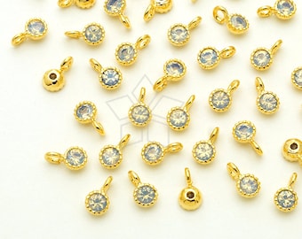 May include: A scattering of gold-toned metal charms with clear, faceted stones. Each charm has a small loop for attaching to jewelry.