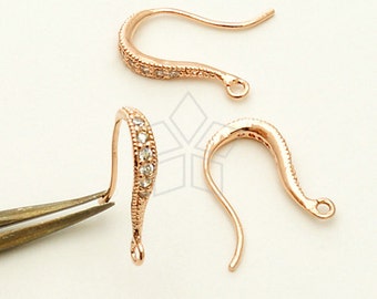 May include: Three rose gold earring hooks with clear crystal accents. The hooks are designed with a slight curve and a small loop at the end.