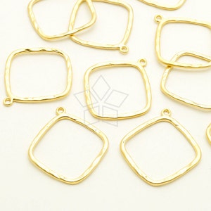 May include: A group of ten gold-toned metal square-shaped pendant frames with a hammered texture. Each frame has a small loop at the top for attaching to a chain or cord.