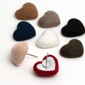 May include: Assortment of heart-shaped fabric earrings in various colours, including red, brown, beige, white, black, blue, and green. The earrings are made of soft, fuzzy fabric and have silver posts.